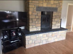 a fake brick fireplace with a television and a flat screen at Leghowney House in Donegal