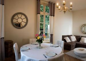 une salle à manger avec une table et un vase de fleurs dans l'établissement Appart Privé dans le Château du Landin, à Le Landin