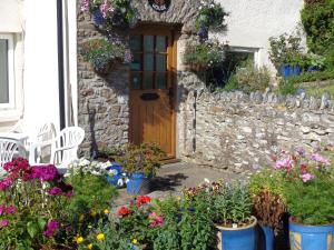 a house with a bunch of flowers in front of it at Lodge House B&B in Buckland St Mary