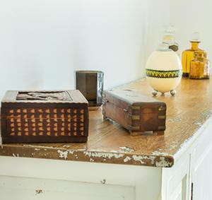 a table topped with wooden boxes and a vase at Raminhos Guest House in Vila Nova de Milfontes