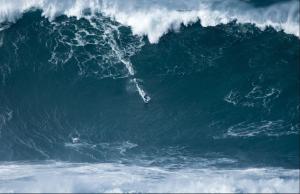 a surfer riding a large wave in the ocean at Beach House Ericeira in Ericeira