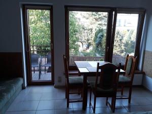 a dining room with a table and chairs and windows at Willa Reda in Świnoujście