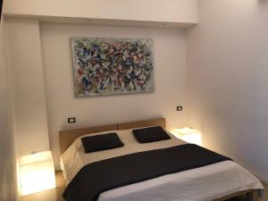 維洛納的住宿－羅密歐設計客房酒店，卧室配有一张床,墙上挂有绘画作品