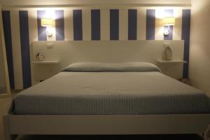 ein Schlafzimmer mit einem Bett mit gestreifter Wand in der Unterkunft Sogno Salento monolocali in Porto Cesareo