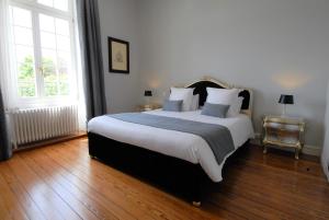 a bedroom with a large bed with white sheets and pillows at Domaine de Bayeux in Bayeux