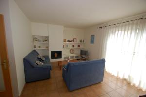 a living room with two blue chairs and a television at Daró 3D 37 Airco Mas Pinell in Torroella de Montgrí