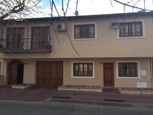 a large house with wooden doors and windows at Departamentos de Buen Nivel in Mendoza