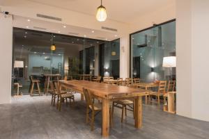 a dining room with wooden tables and chairs at Here Homestay in Zhongpu
