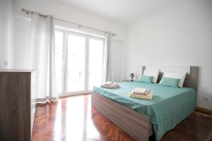 ein Schlafzimmer mit einem Bett und einem großen Fenster in der Unterkunft Akicity Graca Silver in Lissabon