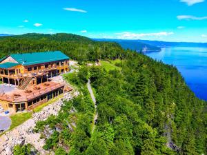 an aerial view of a house on a hill next to the water at Auberge Cap au Leste in Sainte-Rose-du-Nord