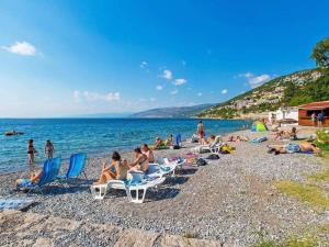 a group of people sitting in chairs on a beach at Apartman BubaMara in Sveti Juraj
