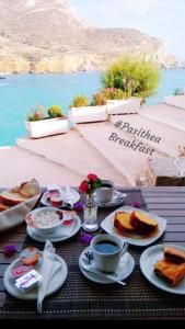 een tafel met borden en kopjes koffie bij Pasithea Folegandros in Agali