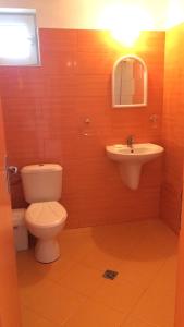 a bathroom with a toilet and a sink at Family Hotel Perla in Golden Sands +65 photos