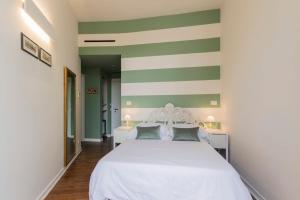 a bedroom with a white bed with green and white stripes at Mediterraneo Emotional Hotel & Spa in Santa Margherita Ligure