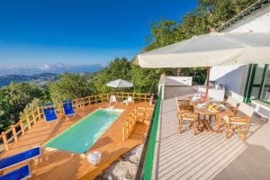 een terras met een zwembad en een tafel en stoelen bij Villa Cosimo in Cefalù