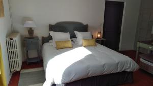 a bedroom with a large white bed with yellow pillows at La Blinerie in Sambin