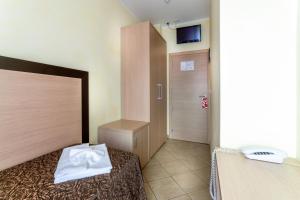a bedroom with a bed with a white towel on it at Hotel Rubens in Rimini