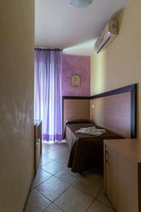 a small bedroom with a bed and a window at Hotel Rubens in Rimini