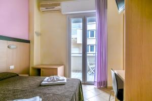 a bedroom with a bed and a window with a balcony at Hotel Rubens in Rimini +37 photos