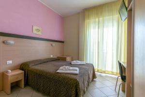 a hotel room with a bed and a window at Hotel Rubens in Rimini