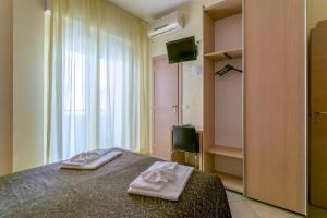 a bedroom with a bed with two towels on it at Hotel Rubens in Rimini