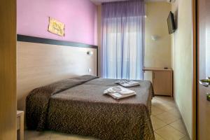 a hotel room with a bed with two towels on it at Hotel Rubens in Rimini