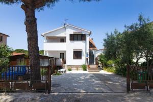 una casa bianca con un cancello e un albero di Apartment Maja a Štinjan