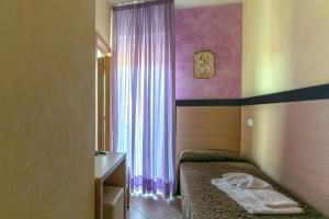 a bedroom with a bed and a sink and a window at Hotel Rubens in Rimini