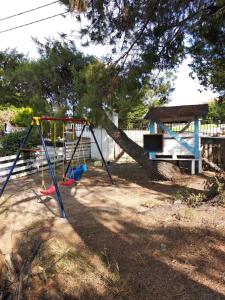 a swing set in a yard with a tree at Avra Ηouse in Kriopigi