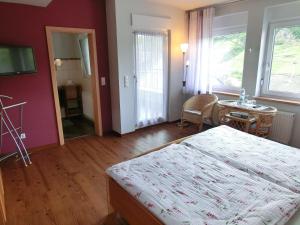 ein Schlafzimmer mit einem Bett und einem Tisch sowie ein Zimmer in der Unterkunft Ferienweingut Hirschen Schulstraße in Burg (an der Mosel)