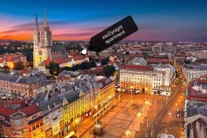 a view of a city at night with a sign that reads schilling university at eazZynight Center Apartment in Zagreb