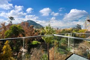 een glazen balkon met uitzicht op bomen en bergen bij Hotel Ismael in Santiago