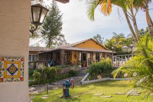 a yellow house with a fire hydrant in front of it at Pousada Hospedaria da Villa in Tiradentes