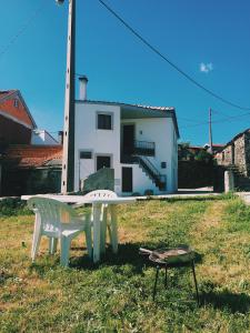 eine Tischtennisplatte und ein Stuhl vor einem Haus in der Unterkunft Casa Urgueira in Pendilhe