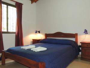 a bedroom with a blue bed with two towels on it at Alma Mora in Merlo