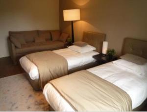 a hotel room with two beds and a couch at Au Charme des Marais in Bourges