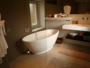 y baño con bañera blanca y lavamanos. en Au Charme des Marais, en Bourges