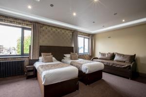 a hotel room with two beds and a couch at Grainger Apartments in Newcastle upon Tyne