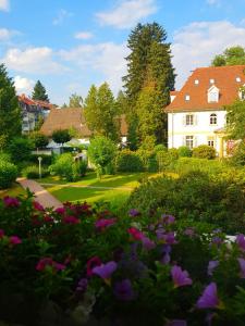 a garden with flowers in front of a white house at Ferienwohnung Sonnenhaft in Baden-Baden