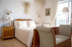 a bedroom with a bed and a chair and a window at Luxurious apt in the Athenian Riviera in Athens