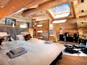 una camera con un grande letto in una stanza con soffitti in legno di Chalet de luxe "Lodge des Sens" - Jacuzzi & Sauna - 12 pers a Bolquere Pyrenees 2000