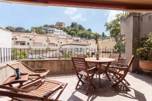 a patio with a table and chairs on a balcony at Lets Holidays apartment terrace La Guardia in Tossa de Mar