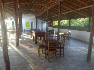 巴雷里尼亚斯Porto dos Lencóis - Chalé Tipo Apartamento的凉亭里带木桌椅的餐厅