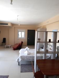 ein Wohnzimmer mit einem Bett und einem Tisch in der Unterkunft Elia & Thalassa in Kalamata