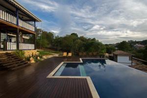a swimming pool on a deck next to a house at Pousada Chão de Minas in Cachoeira do Campo
