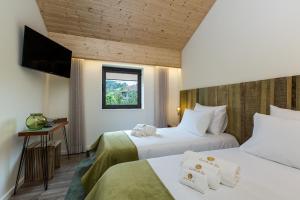 a hotel room with two beds and a window at Quinta Do Rio in Fafe