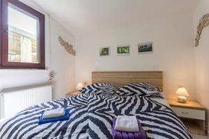 a bedroom with a zebra print bed and a window at Green house, WI-FI, FREE PARKING, GARDEN, HOT TUBE in Peroj