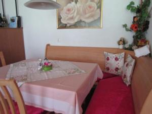 a small table with a pink table cloth and flowers on it at Haus Jochum in Langen am Arlberg