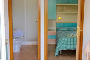 a small bathroom with a bed and a toilet at Villaggio Turistico Defensola in Vieste