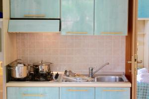 a kitchen counter with two pots and a sink at Villaggio Turistico Defensola in Vieste